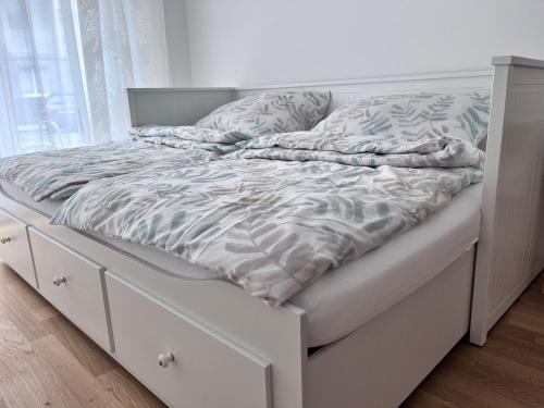 维也纳Danube22 Apartment的一张带白色床架和窗户的未铺好的床