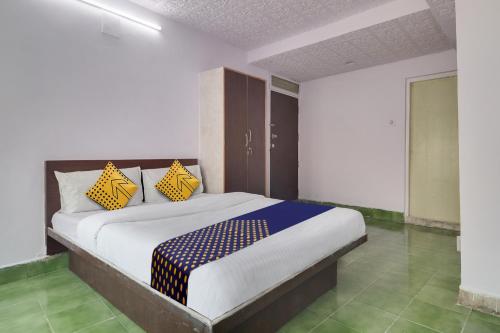 海得拉巴SPOT ON Apsara Hotel的一间卧室配有黄色和蓝色枕头的床