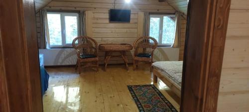 塞尼维斯卡波利亚纳Крайня Хата的小屋内的房间,配有桌椅