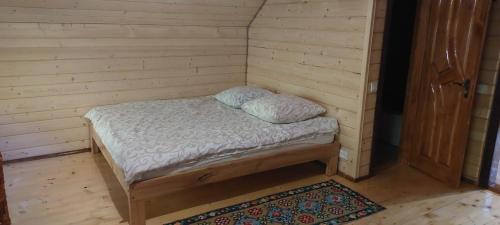 塞尼维斯卡波利亚纳Крайня Хата的一张小床,位于客房的角落