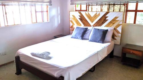 阿卡西亚斯Casa de descanso acacias meta的卧室配有带蓝色枕头的大型白色床