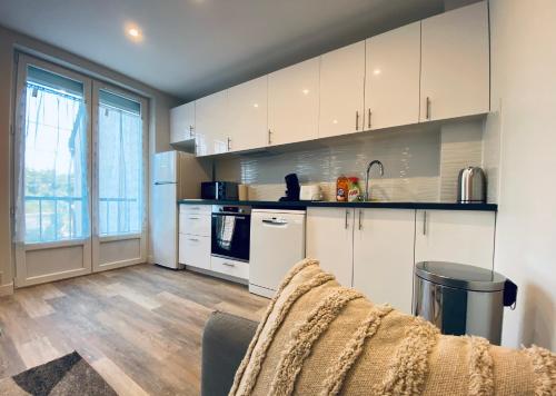 帕莱索Cozy appart' a deux pas de la gare - Cozy Houses的厨房配有白色橱柜和炉灶烤箱。