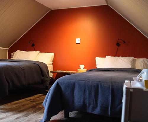 MatapediaChez Casimir的橙色墙壁的客房内的两张床