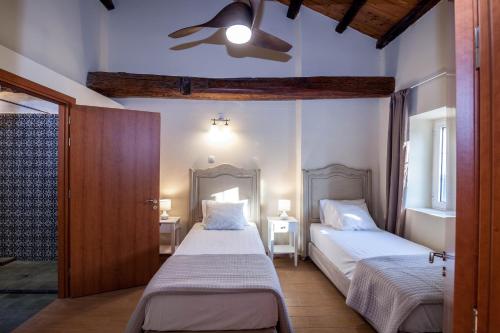 StrongylíMarcora's Historical Estate的一间卧室配有两张床和吊扇