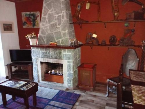 坎波斯杜若尔当Casa do Passarinho的客厅设有石制壁炉和桌子。