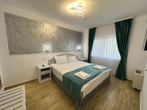 百乐费利克斯Apartamente CasaBella的一间卧室配有一张带绿色床单的大床和窗户。