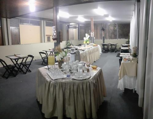 巴乌鲁Falcon Hotel的一组桌子,位于一间有白色桌布的房间