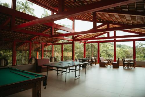 瓜佩Cachoeira do Macuco Boutique Hotel的配有乒乓球桌和椅子的房间