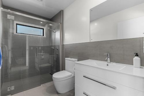 Waipu CoveModern Sanctuary - Waipu Holiday Home的浴室配有卫生间、盥洗盆和淋浴。