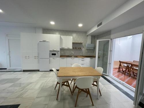 科尼尔-德拉弗龙特拉El Rincón de Madera - Apartamento céntrico en Conil的厨房配有木桌和白色家电