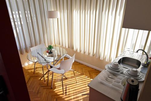 拉巴斯佐纳苏尔玻利维亚客房套房旅馆的厨房配有桌子、两把椅子和一张桌子