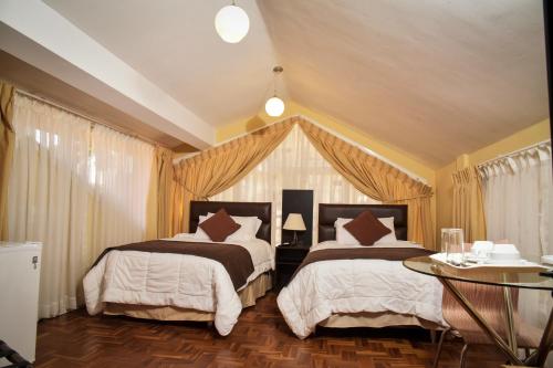 拉巴斯佐纳苏尔玻利维亚客房套房旅馆的一间卧室配有两张床和一张桌子