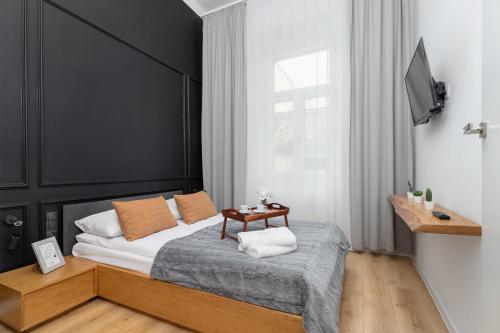克拉科夫Apartment with Mezzanine - Ariańska 14 by Renters的一间卧室配有一张带黑色床头板和一张桌子的床。