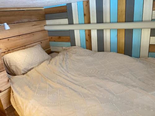 北谷町Surfer's Cafe& Hostel的卧室内的一张床位,配有木制床头板