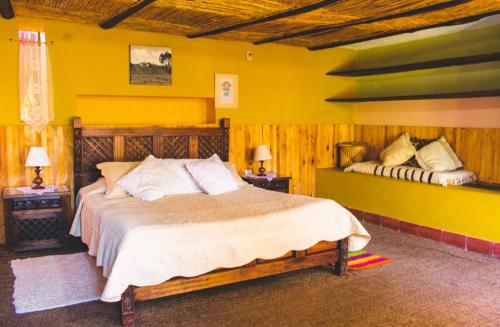 瓜斯卡Hotel Finca el Recreo的一间卧室设有一张大床和黄色的墙壁