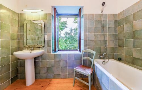 Caylus凯吕斯16号度假屋的一间带水槽和浴缸的浴室以及窗户。