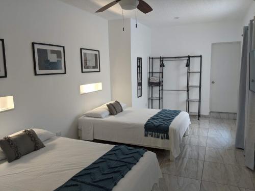 坎昆Hermoso departamento en Cancún YaxBahia 3的一间卧室配有两张床和吊扇