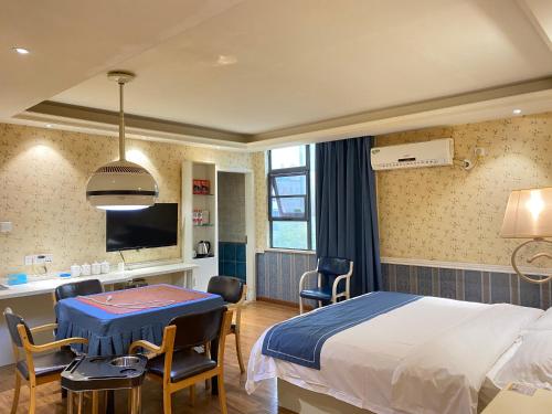 长沙莫林风尚酒店长沙涂家冲地铁站店的一间医院间,配有一张床和一张桌子及椅子