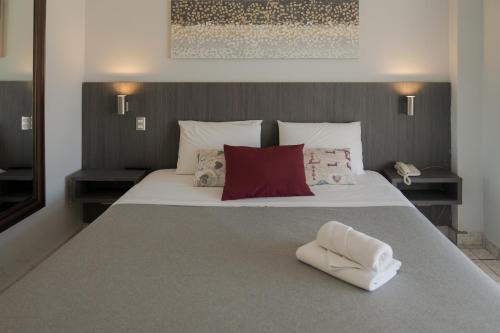 圣地亚哥Red Hotel Centric Santiago的卧室配有带红色枕头的大型白色床