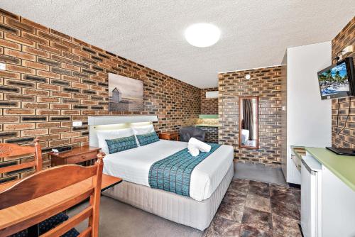 史丹霍普苹果和葡萄汽车旅馆 的一间卧室设有一张床和砖墙
