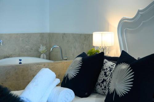 曼哲拉Villa by the Sea的客房设有带枕头的沙发和浴缸。