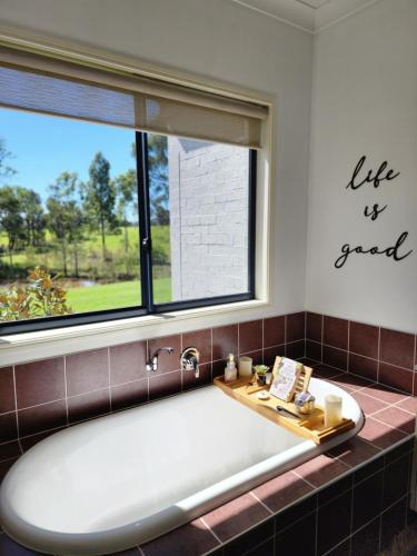 波高尔宾Red Door Collective - RDC Vineyard Estate的带浴缸的浴室和窗户