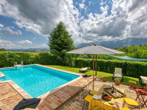 AmandolaCountryside Villa in Amandola with Swimming Pool的一个带遮阳伞和桌椅的游泳池