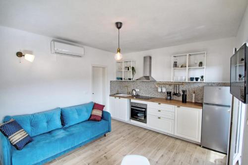 维尼埃拉茨Apartments Kondrić的客厅设有蓝色沙发,厨房设有