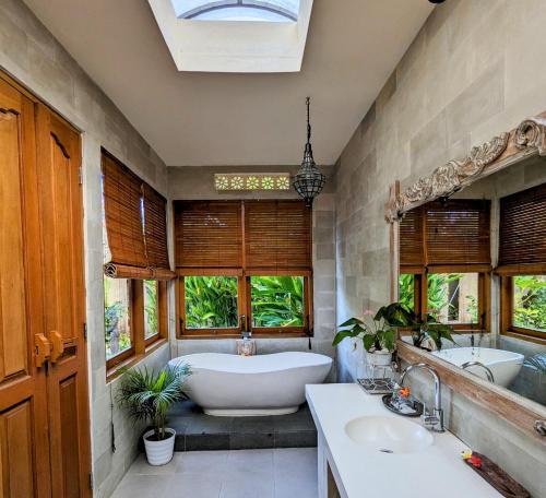 乌布Villa Ulun Mertha - 1BR Private Villa的一间带两个盥洗盆和浴缸的浴室以及窗户。