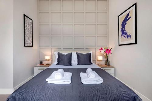伦敦Contemporary Clapham Living的一间卧室配有一张带两条白色毛巾的床