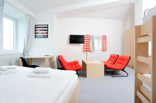 斯塔雷梅斯托Penzion Kraličák的一间卧室配有红色椅子、一张床和一张书桌