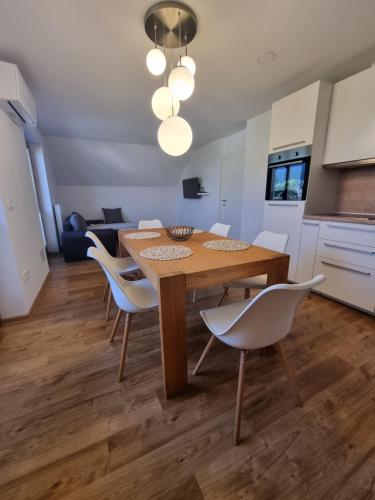 佐尔尼耶戈迪Apartment 199的厨房以及带木桌和椅子的用餐室。