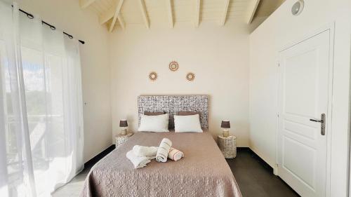Cul de SacLe Martini-Vue MER et PINEL terrasse piscine的一间卧室,床上有两双鞋
