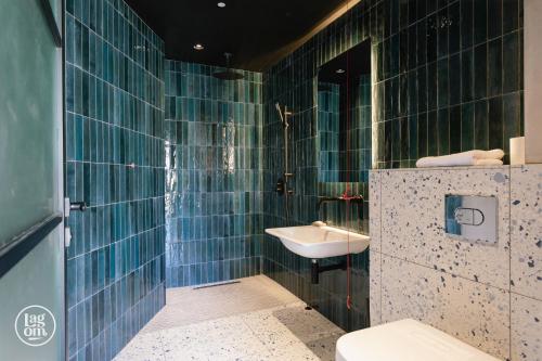 巴利卡斯尔StayLagom的蓝色瓷砖浴室设有水槽和卫生间