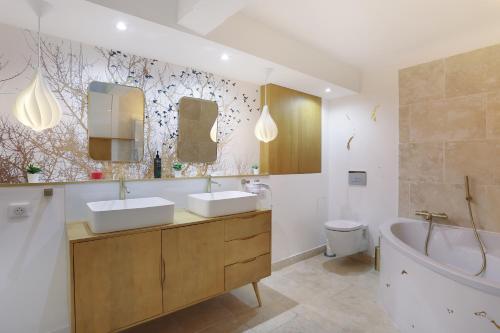 普罗旺斯艾克斯Les suites de Montigny的一间带两个盥洗盆、浴缸和卫生间的浴室