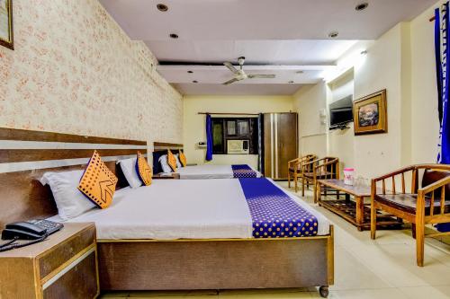 新德里Flagship Hotel Swagat Palace的一间卧室配有一张床和两把椅子