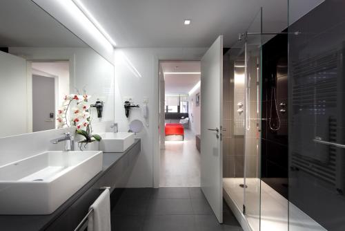 马德里优斯达赛特酒店的一间带水槽和玻璃淋浴的浴室