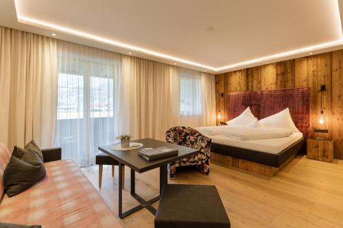 齐勒河谷采尔Hotel Garni Jagdhof的酒店客房配有一张床铺和一张桌子。