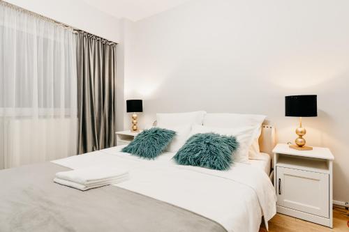 克卢日-纳波卡Beautiful and cozy 2 bedroom apartment with living room loft的一张带两个绿色枕头的白色床