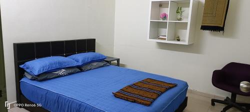 昔加末RW segamat homestay的一间卧室配有一张带蓝色床单的床和一把椅子