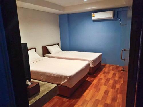 清迈Airport A1 Hotel的配有蓝色墙壁和木地板的客房中的两张床