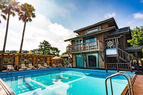 济州市戴恩度假村的房屋前有游泳池的房子