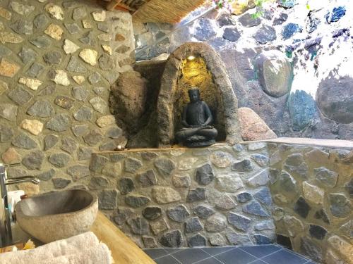 罗威那罗威那欣欣度假村的石质浴室设有水槽和石墙