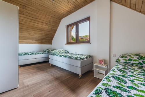 GrywałdDomki Pieniny的一间卧室设有两张床和木制天花板