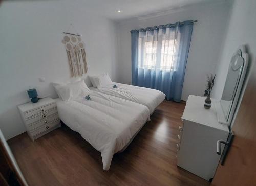 Casais de São MamedeCasa da Avo dos Anjos的一间卧室配有一张床、一个梳妆台和一扇窗户。