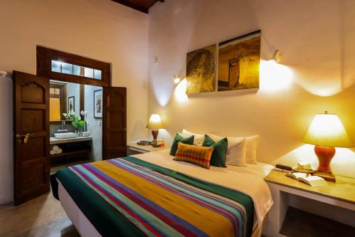康提Margossa Residence by 55TG的一间卧室配有一张床和一张带台灯的书桌