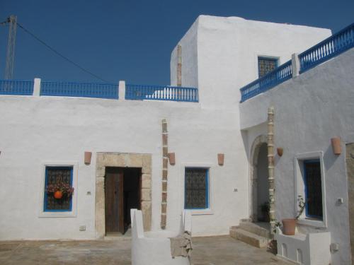 乌姆苏克Dar Michèle Djerba的白色的建筑,上面有门和楼梯