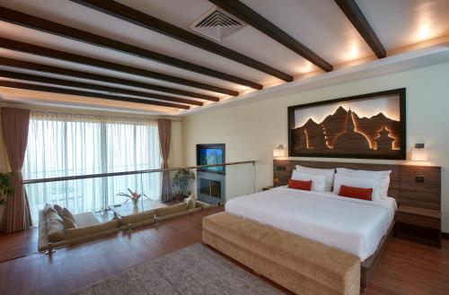 图利凯尔杜利克尔度假酒店的卧室配有一张白色的大床和一张沙发。