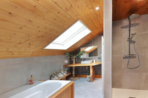 热拉梅Granit'Home的带浴缸和天窗的浴室