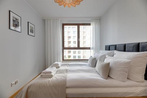 格但斯克Downtown Apartments Garnizon的白色卧室设有一张大床和窗户